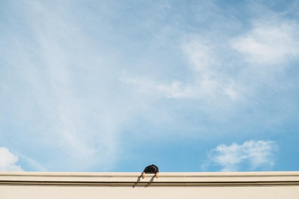 Picture of blue sky above a person standing on a roof terrace. 